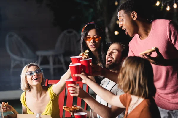 Gente Interracial Emocionada Brindando Con Tazas Plástico Sosteniendo Pizza Aire — Foto de Stock