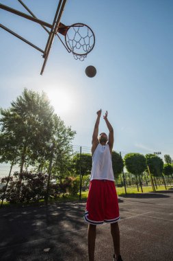 Afro-Amerikan oyuncunun basketbol potasını dışarı fırlatması geniş açılı bir bakış açısı. 