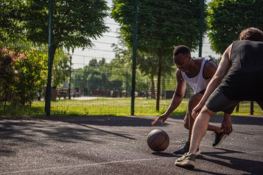 Afrika kökenli Amerikalı sporcu oyun parkında arkadaşının yanında sokak topu oynuyor. 
