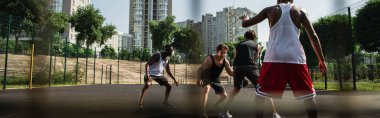 Sporcu, dışarıda çok ırklı insanlarla sokak basketbolu oynuyor. 