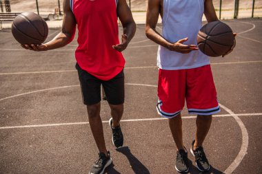 Afrika kökenli Amerikalı basketbolcuların açık havada oyun sahasında yürümeleri. 