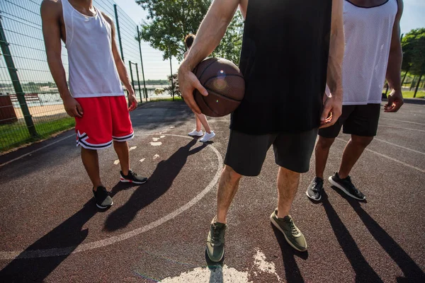 Gehakt Uitzicht Man Houden Basketbal Buurt Van Afrikaanse Amerikaanse Vrienden — Stockfoto