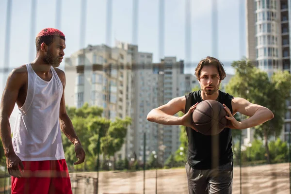 Hombre Con Pelota Baloncesto Mirando Cámara Cerca Afroamericano Deportista Aire — Foto de Stock