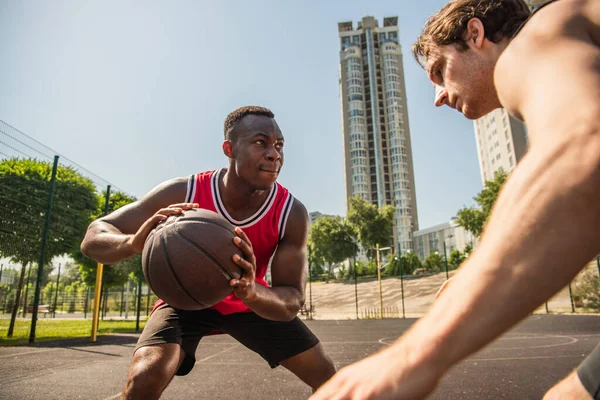 Soustředěný Africký Americký Hráč Drží Basketbal Blízkosti Přítele Během Soutěže — Stock fotografie