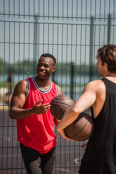 Boldog Afro Amerikai Sportoló Kezében Kosárlabda Közel Kerítés Homályos Barát — Stock Fotó