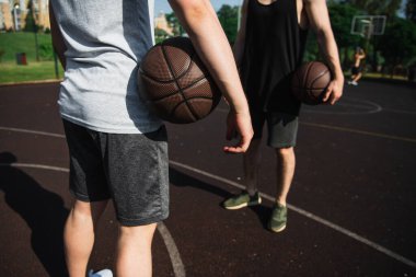 Oyun sahasında basketbol topu tutan erkeklerin görüntüsü. 
