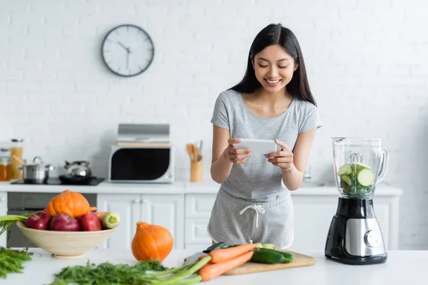 Sorrindo Mulher Asiática Tirar Foto Legumes Frescos Smartphone Cozinha — Fotografia de Stock