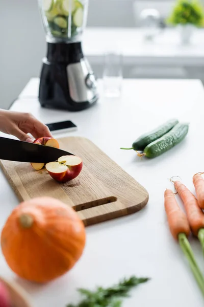 Gedeeltelijk Uitzicht Vrouw Snijden Appel Buurt Wazig Pompoen Wortelen Tafel — Stockfoto