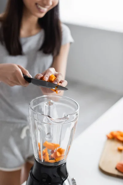 用刀把南瓜切入振动器的模糊妇女的局部视图 — 图库照片