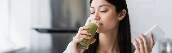 Pleased Asian Woman Smartphone Drinking Tasty Smoothie Closed Eyes Banner — Stock Photo, Image