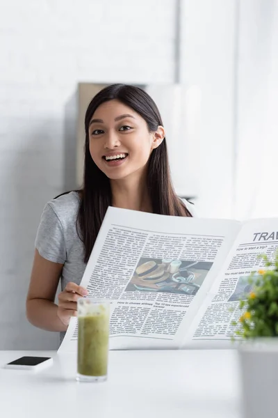 Cheerful Asian Woman Smiling Camera While Standing Newspaper Blurred Glass — Stock Photo, Image