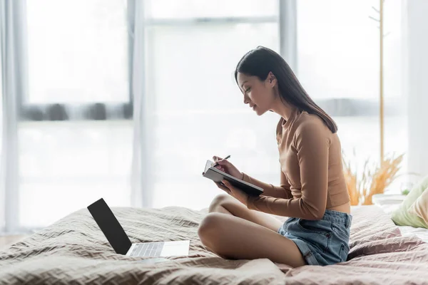 Vista Lateral Mujer Asiática Sentada Cama Con Las Piernas Cruzadas — Foto de Stock