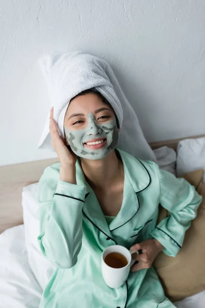 Glad Asiatisk Kvinna Med Handduk Huvudet Och Lera Mask Ansiktet — Stockfoto