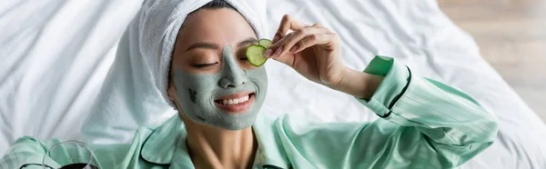 Alegre Asiático Mujer Arcilla Máscara Aplicación Fresco Pepino Rebanadas Ojo — Foto de Stock
