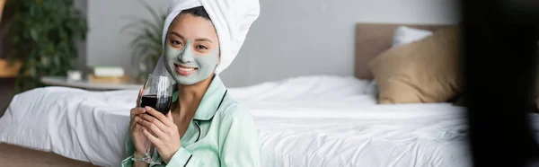 Mujer Asiática Alegre Con Máscara Arcilla Toalla Cabeza Sosteniendo Vaso — Foto de Stock