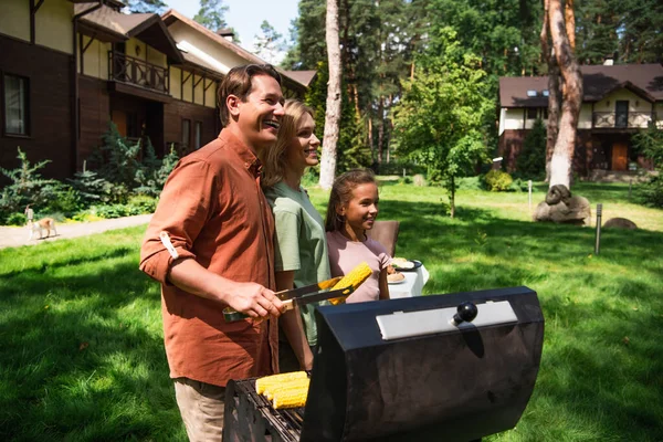 Sonriente Familia Pie Cerca Padre Cocinando Maíz Parrilla Durante Fin —  Fotos de Stock