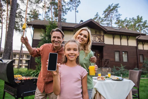 Girl Showing Smartphone Smiling Parents Food Grill Outdoors — Stock Photo, Image