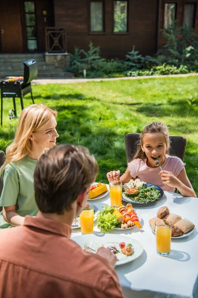 Kid Eating Salad Looking Father Picnic Outdoors — Stock Photo, Image