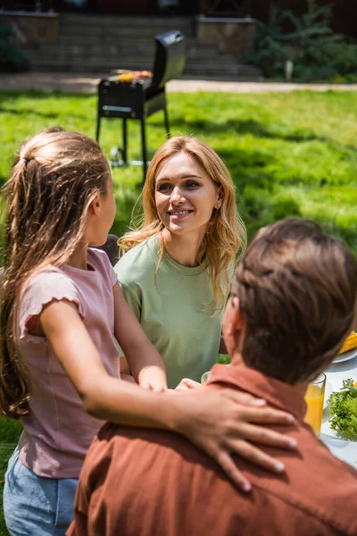 Smiling Woman Looking Blurred Child Husband Picnic — Stock fotografie