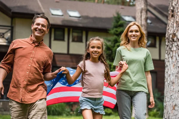 Leende Barn Håller Amerikansk Flagga Nära Föräldrar Utomhus — Stockfoto