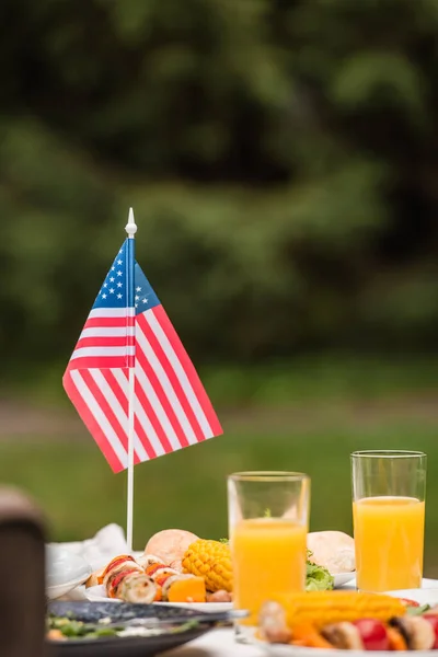 Amerikansk Flagga Nära Grillade Grönsaker Och Apelsinjuice Utomhus — Stockfoto