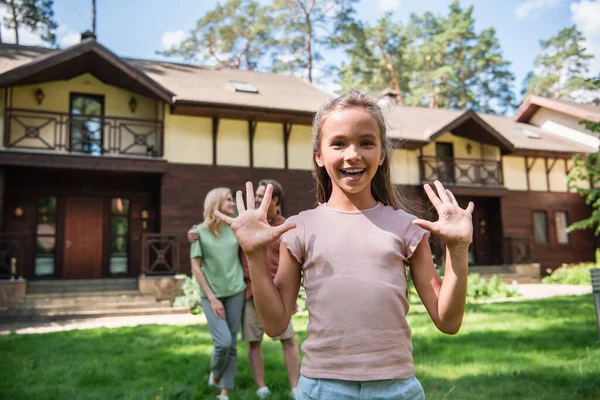 Smiling Girl Waving Hands Blurred Parents Outdoors Vacation — Stock Photo, Image