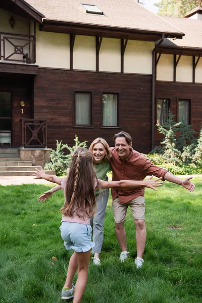 Chica Corriendo Los Padres Sonrientes Cerca Casa Vacaciones — Foto de Stock