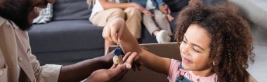 Kutu içinde gülümseyen Afrikalı Amerikalı kız babama anahtarı veriyor.