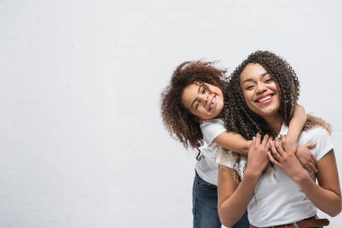 Mutlu Afro-Amerikan annesini kucaklayan neşeli çocuk.