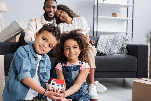 Cheerful African American Siblings House Model Happy Parents Blurred Background — Stock Photo, Image