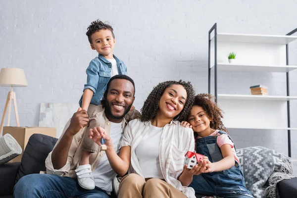 Alegre Afroamericano Familia Sonriendo Cámara Sofá Nuevo Apartamento — Foto de Stock