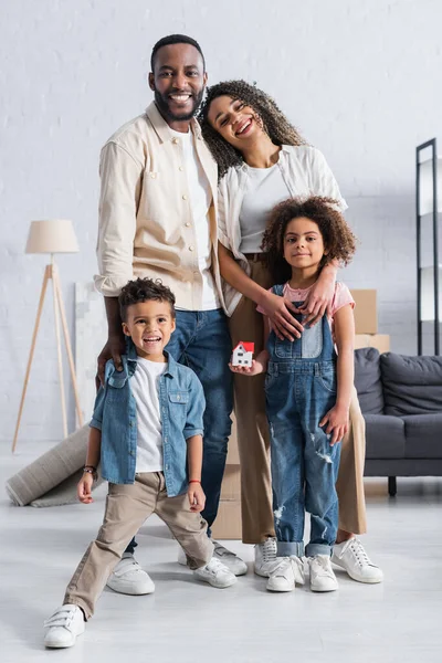 Alegre Afroamericano Familia Sonriendo Cámara Mientras Pie Nuevo Apartamento —  Fotos de Stock