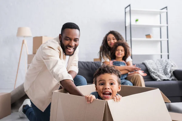 Garoto Americano Africano Assustado Caixa Papelão Perto Família Alegre Novo — Fotografia de Stock