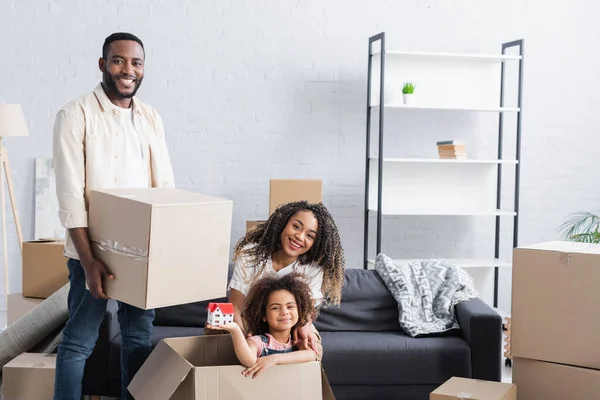 Menina Americana Africana Feliz Caixa Papelão Segurando Modelo Casa Perto — Fotografia de Stock