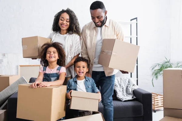 Familia Afroamericana Emocionada Sosteniendo Paquetes Cartón Nuevo Apartamento — Foto de Stock