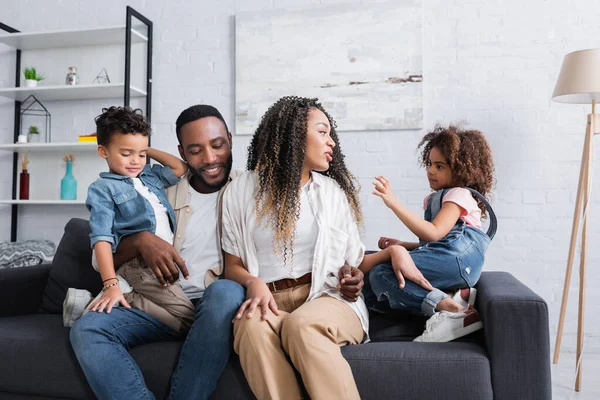 Feliz Africano Americano Pareja Hablando Con Niños Sofá Casa —  Fotos de Stock