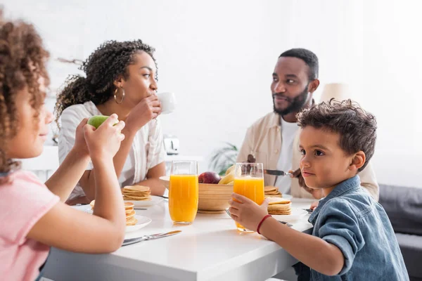 アフリカ系アメリカ人の女性が家族と朝食中にコーヒーを飲み — ストック写真