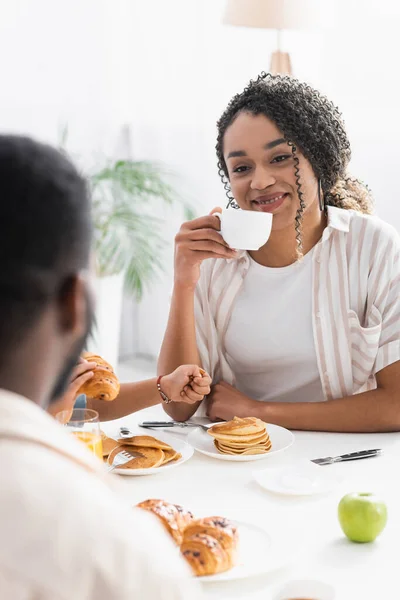 Happy African American Woman Drinking Coffee Son Blurred Husband — Stock Photo, Image