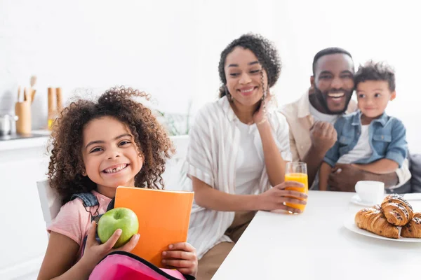 Afroamericana Chica Con Manzana Portátil Cerca Borrosa Familia Cocina —  Fotos de Stock