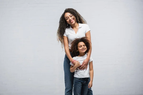 Happy Woman Looking Camera While Hugging African American Daughter Grey — Stock Photo, Image