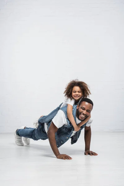 Alegre Africano Americano Chica Piggybacking Feliz Papá Haciendo Flexiones Gris — Foto de Stock