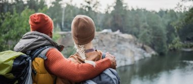 back view of man hugging woman near lake, banner