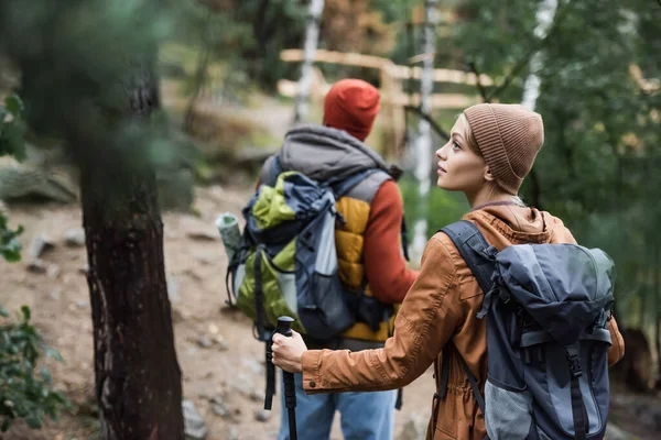 Mladá Žena Batohem Dívá Pryč Blízkosti Muže Trekking Lese Rozmazaném — Stock fotografie