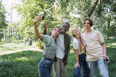 Parkta selfie çeken pozitif ırklar arası gençler. 