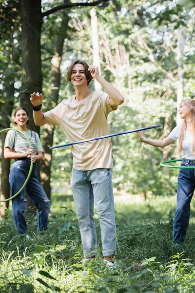 Adolescente Sorrindo Torcendo Hula Hoop Perto Amigos Alegres Fundo Borrado — Fotografia de Stock