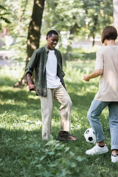 Usmívající Africký Americký Teenager Hrát Fotbal Přítelem Parku — Stock fotografie