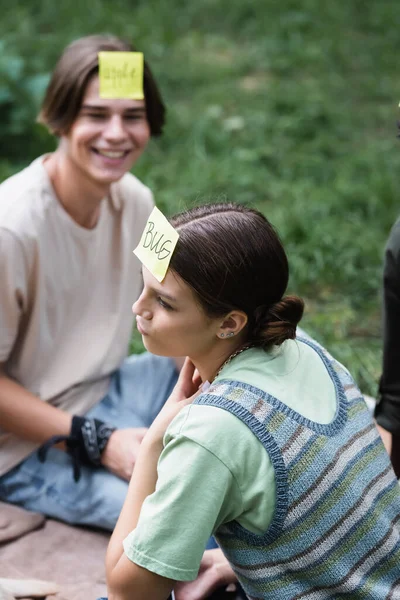 Pensativo Adolescente Jugando Quién Soy Juego Cerca Sonreír Amigo Parque — Foto de Stock