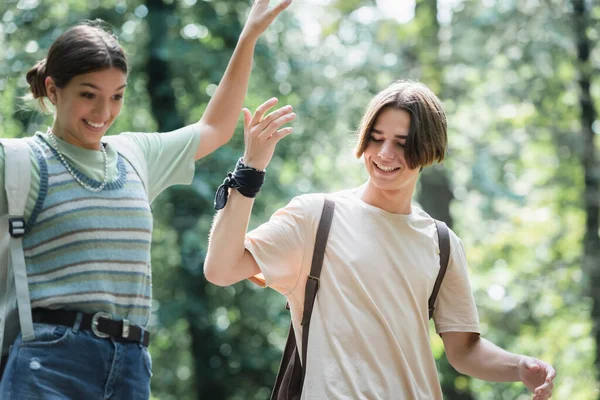 Adolescente Sorrindo Perto Amigo Borrado Com Mochila — Fotografia de Stock