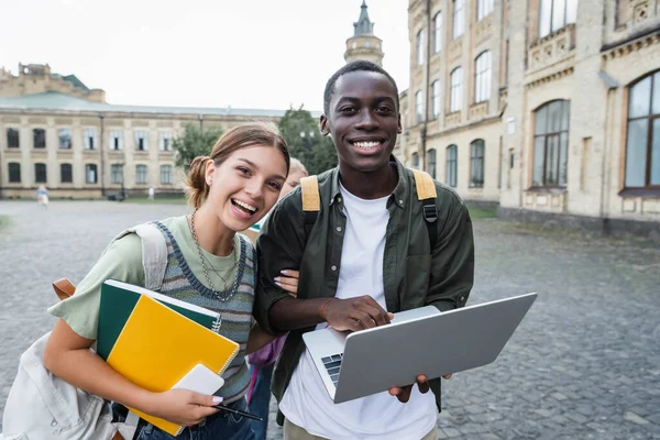 Usmívající Africký Americký Student Drží Notebook Blízkosti Přítele Notebooky Venku — Stock fotografie