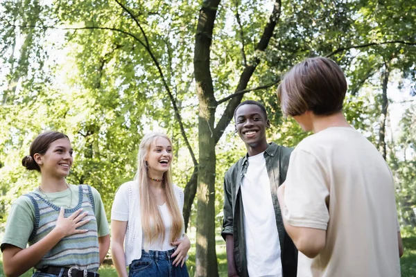 笑着和公园里的朋友聊天的跨种族青少年 — 图库照片